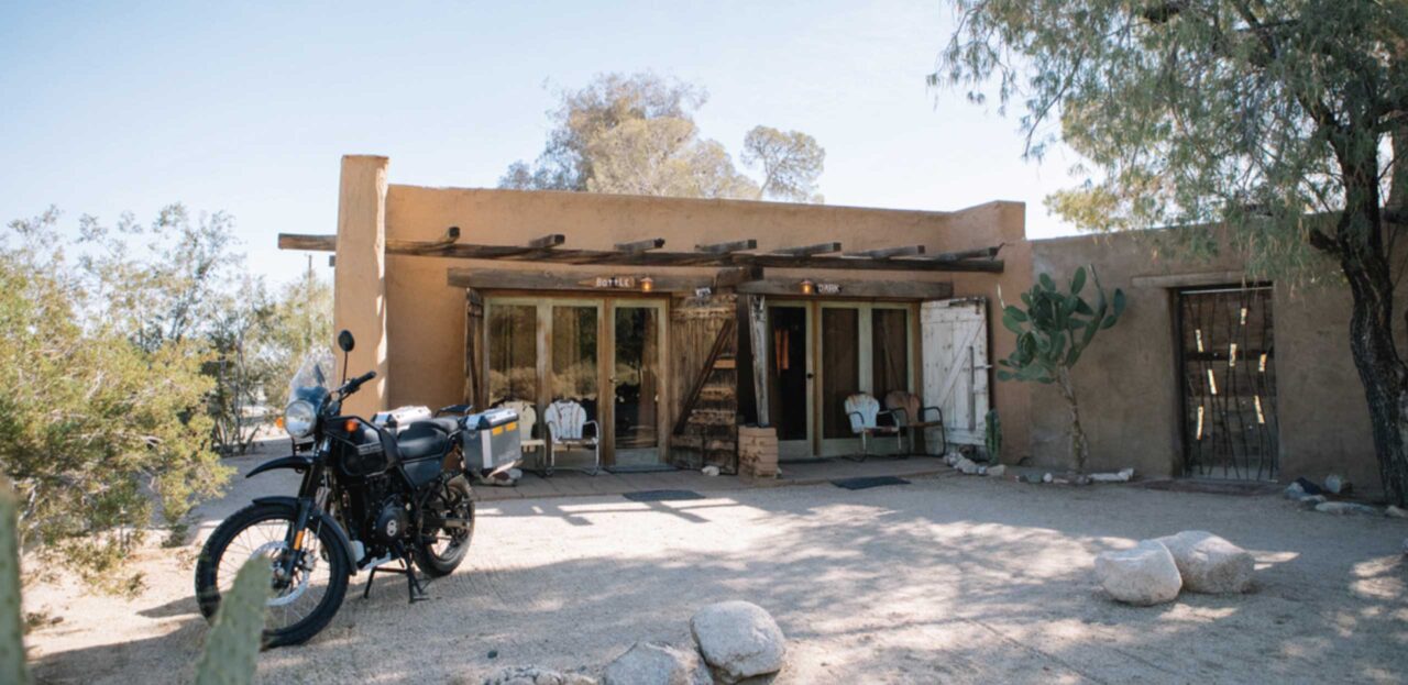 A motorcycle parked in front of Bottle Room and Dark Room